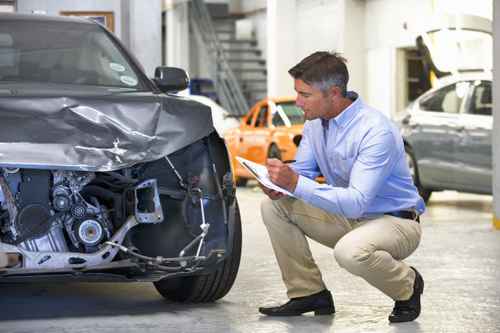 Insurance assessor inspecting damaged vehicle Service Instandsetzung Unfallreparatur Wartung Inspektion Markenoffen Norm Tüv Hersteller Qualtiät Schnell